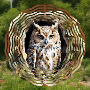 May include: A metal wind spinner with a brown owl design. The owl is perched in a tree with green leaves. The wind spinner has a circular shape with a layered design.