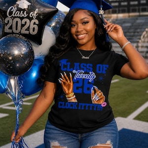 May include: A person wearing a graduation cap and a black t-shirt with the text "Class of Twenty 26 Clock Itttt!!" and a graduation cap graphic. The person is holding blue and black balloons, including a star-shaped balloon that says "Class of 2026".