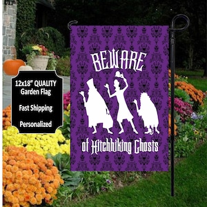 Purple garden flag with 3 hitchhiking ghosts in white in front of.  Cute halloween flag.