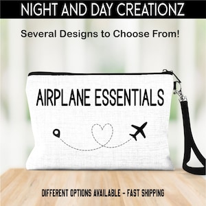 May include: White canvas zippered pouch with a black zipper and a black strap. The pouch has a black airplane graphic with a heart and a dotted line. The text "AIRPLANE ESSENTIALS" is printed in black on the pouch.