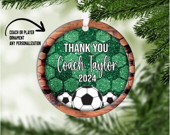 May include: Green glitter soccer ornament with a woodgrain border. The ornament says "Thank You Coach Taylor 2024".