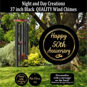 May include: Black wind chimes, 37 inches long, with a wooden top and clapper. The wind chimes have a black finish and are hanging in a garden setting. The image includes a black disc with gold text that reads "Happy 50th Anniversary".