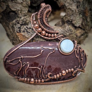 May include: A white ceramic mug with a black handle and the text "But First, Coffee" in a bold, black font. The mug is set against a blurred background, suggesting a cozy setting.