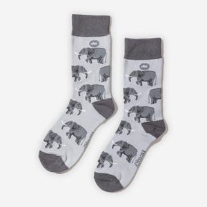 Könnte beinhalten: Ein Paar hellgraue Socken mit einem Muster aus grauen Elefanten. Die Socken haben dunkelgraue Fersen, Zehen und Bündchen. Der Markenname ist weiß auf der Seite einer Socke aufgedruckt.