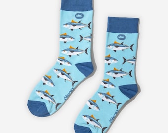 May include: A pair of light blue socks with a repeating pattern of tuna fish. The socks have dark blue heels, toes, and cuffs. The tuna fish are white, blue, and yellow.