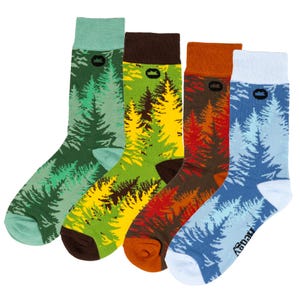 May include: Four pairs of colorful socks with a forest print. The socks are green, yellow, orange, and blue. Each sock has a small black logo on the top.