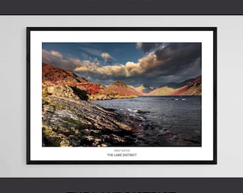 May include: A framed landscape photograph of Wast Water in the Lake District, featuring a dark, rocky shoreline, deep blue water, and distant mountains under a dramatic, cloud-filled sky. The print includes the text WAST WATER THE LAKE DISTRICT.