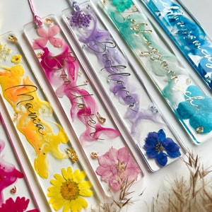 Pu&ograve; includere: Sei segnalibri colorati con fiori pressati e lettere dorate. I segnalibri sono realizzati in resina trasparente e presentano una variet&agrave; di colori, tra cui rosa, blu, giallo e viola. Le scritte sui segnalibri includono "Bookworm", "Booklover", "Reading is my superpower", "Botanica" e "Good Vibes".