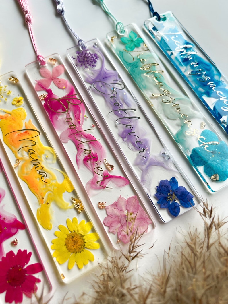 Pu&ograve; includere: Sei segnalibri colorati con fiori pressati e lettere dorate. I segnalibri sono realizzati in resina trasparente e presentano una variet&agrave; di colori, tra cui rosa, blu, giallo e viola. Le scritte sui segnalibri includono "Bookworm", "Booklover", "Reading is my superpower", "Botanica" e "Good Vibes".