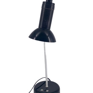 a black desk lamp with a white base