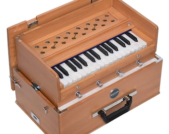 May include: A wooden harmonium with a keyboard, bellows, and a carrying handle. The harmonium is open and the bellows are visible. The harmonium is labeled "BHAVA".