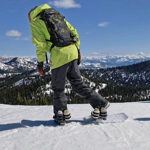 Snowboarder Strapping into Snowboard with 4 Beer Binding Pro models strapped to bindings.