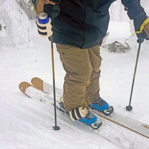 Beer Binding Pro can strapped to ski pole and boot buckle