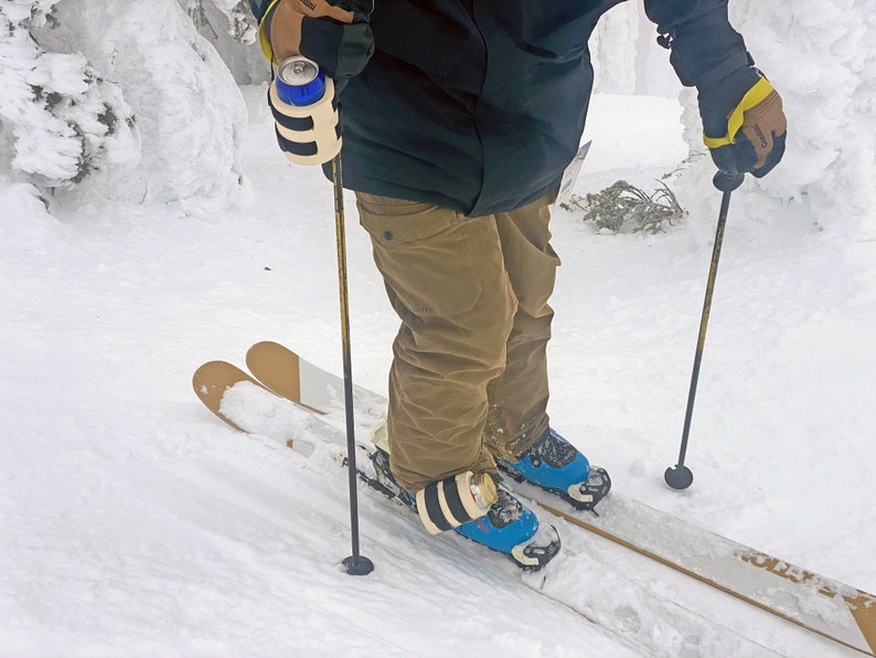 Beer Binding Pro can strapped to ski pole and boot buckle