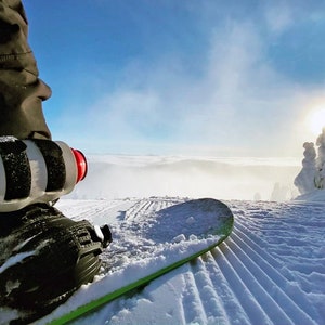 Beer Binding Pro strapped to Snowboard on Mountain saint bernard style