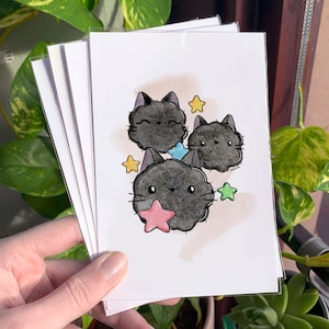 Puede incluir: Tres gatos negros y esponjosos con estrellas blancas y una estrella rosa sobre un fondo blanco.