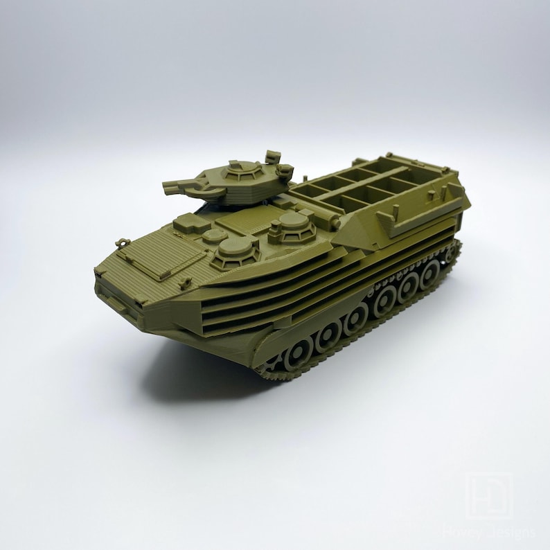 May include: A green military amphibious assault vehicle model with a rotating turret and a cargo bed. The vehicle has a track system and is made of plastic.