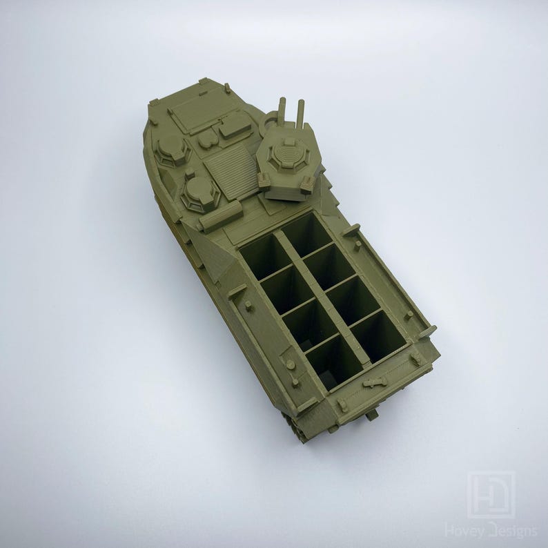May include: A green plastic model of a military amphibious vehicle with a removable turret. The vehicle has a rectangular cargo bed with multiple compartments.
