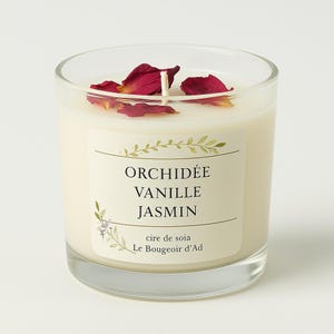 Peut inclure: Un bougeoir en verre transparent avec une cire crémeuse à l'intérieur. La bougie est ornée de pétales rouges et d'une mèche blanche. L'étiquette indique "ORCHIDÉE VANILLE JASMIN" et "cire de soia Le Bougeoir d'Ad".