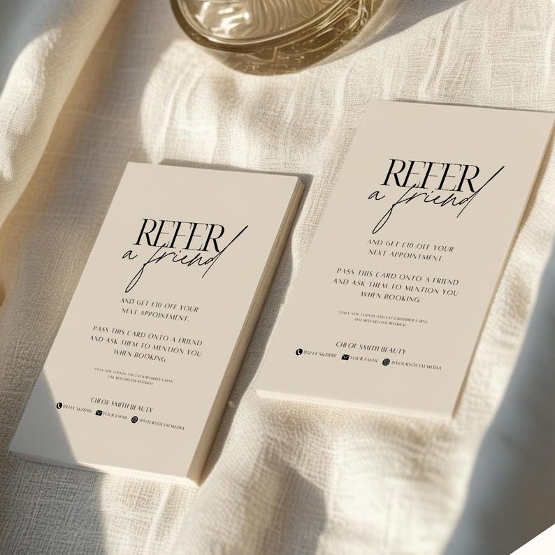 May include: Two beige referral cards with the text "Refer a Friend" in a stylish font. The cards also include the text "And get $10 off your next appointment" and "Pass this card onto a friend and ask them to mention you when booking."