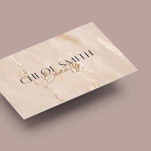 May include: A beige business card with a marble-like background and gold glitter accents. The text "CHLOE SMITH Beauty" is printed in black and gold.