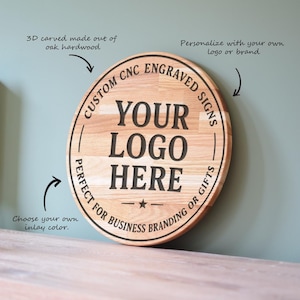Puede incluir: Un letrero redondo de madera con el texto "YOUR LOGO HERE" en negro. El letrero está hecho de madera de roble y presenta las palabras "CUSTOM CNC ENGRAVED SIGNS" y "PERFECT FOR BUSINESS BRANDING OR GIFTS" alrededor del borde.