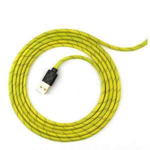 May include: A yellow braided USB cable with a black connector. The cable is coiled up in a circle.