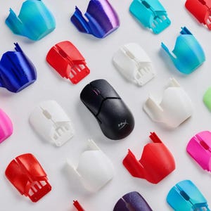 Può includere: Una collezione di cover per gusci di mouse stampate in 3D in vari colori, tra cui rosso, blu, bianco e viola. È inclusa anche una mouse wireless nera con una rotellina di scorrimento rosa.