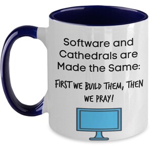May include: White ceramic mug with a navy blue interior and handle. The mug features the text "Software and Cathedrals are Made the Same: FIRST WE BUILD THEM, THEN WE PRAY!" and a blue computer monitor graphic.