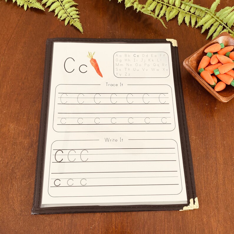 May include: A black and white printable worksheet with the letter "C" and a carrot illustration. The worksheet includes instructions to "Trace It" and "Write It" with dotted lines for tracing and blank lines for writing the letter.
