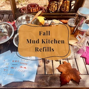 May include: A collection of mud kitchen supplies including stainless steel bowls, glass jars with metal lids, test tubes filled with natural items, and recipe cards labeled Fall Mud Kitchen Refills, arranged on a wooden surface with autumn leaves.