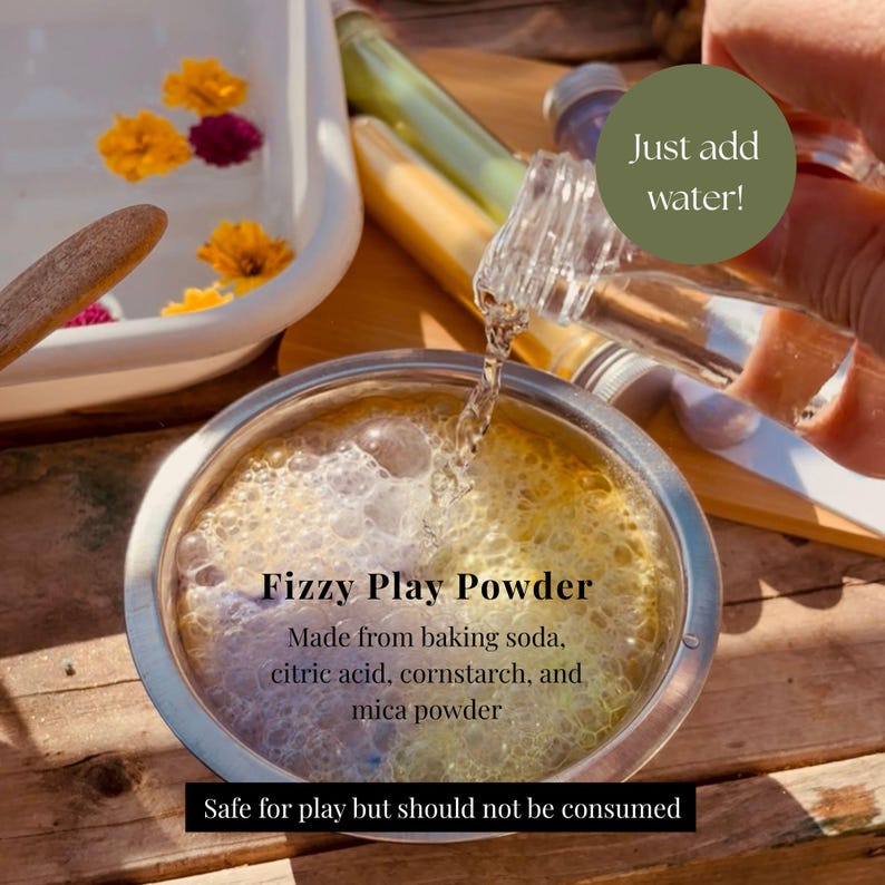 May include: A stainless steel bowl containing Fizzy Play Powder made from baking soda, citric acid, cornstarch, and mica powder. Water is being poured into the bowl, creating bubbles. Text reads: Just add water! Fizzy Play Powder. Safe for play but should not be consumed.