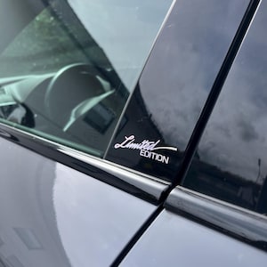 Könnte beinhalten: Ein graues Auto mit schwarzer Fensterverkleidung und einem "Limited Edition" Aufkleber am Fenster.