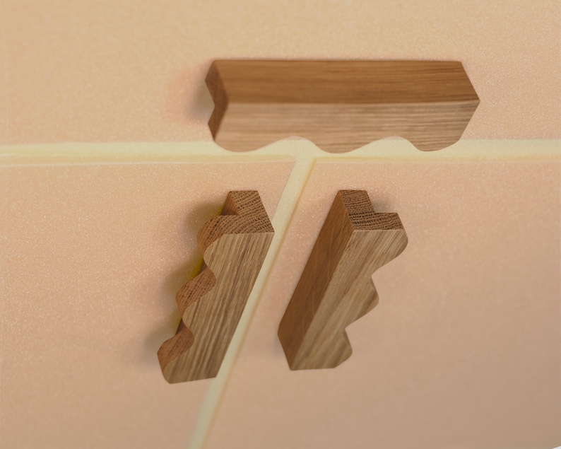 May include: Three wooden pieces with a wavy edge. The pieces are light brown and have a natural wood finish. The pieces are arranged in a triangular shape.