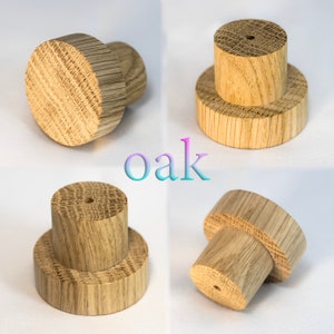 Könnte beinhalten: Vier Ansichten eines Flaschenverschlusses aus Eichenholz. Der Verschluss hat eine zylindrische Form mit rundem Oberteil und kleinerem Sockel. Das Wort "Oak" wird in einer Farbverlaufsschrift angezeigt.