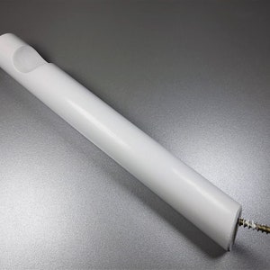 May include: White plastic wall mount with a screw hole and a slot for a rod. The mount is designed to hold a curtain rod.