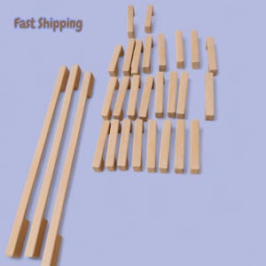 May include: A collection of unfinished wooden cabinet pulls and handles in various sizes. The image shows several long, rectangular pulls and smaller, square-shaped knobs, all made of light-colored wood. The text "Fast Shipping" is visible in the upper left corner.