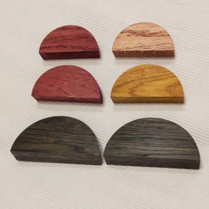 以下が含まれることがあります： 赤、茶色、オレンジ、グレーの様々な色合いの木製の半円形が6つ。 形状は2列3つずつに配置されています。