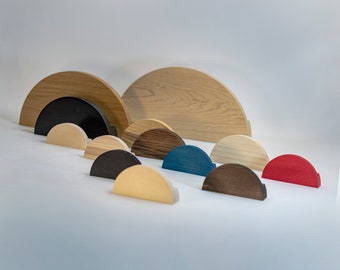 May include: A set of wooden half-circle wall decor pieces in various sizes and colors, including natural wood, black, dark brown, light brown, blue, and red.