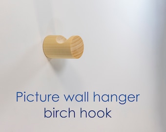 Krok för väggtavlor. Liten träkrok för väggen. Minimalistisk krok för att hänga modern konst. Modern hängande väggförvaring inkluderar skruvfästen.
