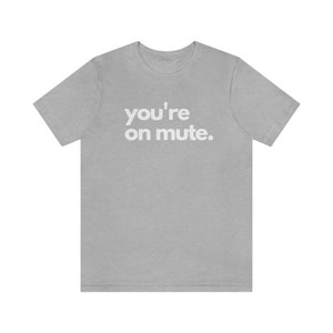 Peut inclure: Un t-shirt gris chiné avec le texte "you're on mute." imprimé en blanc.