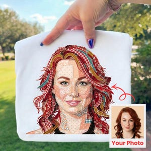 May include: White sweatshirt featuring a portrait of a woman with red hair, created with a patchwork design. The portrait is accompanied by a smaller photo with the text "Your Photo". The sweatshirt is held up by a hand.