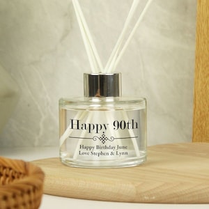 Puede incluir: Una botella de difusor de vidrio transparente con tapa plateada y texto negro que dice "Happy 90th" y "Happy Birthday June Love Stephen & Lynn".
