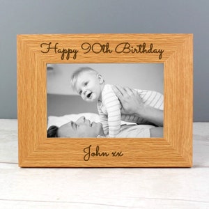 May include: A wooden photo frame with a black and white photo of a father and child. The frame is engraved with the text "Happy 90th Birthday John xx".