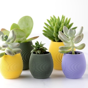 May include: A white ceramic mug with a black handle and the text "But First, Coffee" in a bold, black font. The mug is filled with a dark liquid, probably coffee, and rests on a light-coloured surface.