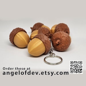 May include: A set of six brown acorn-shaped keyrings with a gold-coloured cap. The keyrings are attached to a silver key ring. The image includes the text "Order these at angelofdev.etsy.com".