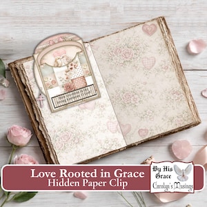 May include: An open book with floral and heart-patterned pages. A hidden paper clip featuring a dove design and the text "How excellent is thy loving kindness O God" is inserted. The text "Love Rooted in Grace Hidden Paper Clip" is at the bottom.
