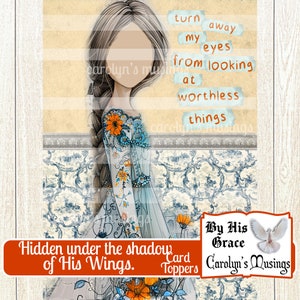 May include: A digital printable card topper featuring a watercolor illustration of a woman with long brown hair, wearing a blue and white dress with floral details. The text "Hidden under the shadow of His Wings." is printed in red at the bottom of the card. The text "By His Grace" and "Carolyn's Musings" is printed in black at the bottom right corner of the card.