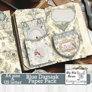 May include: A blue and white damask patterned paper pack with a variety of decorative elements, including a pocket, a label, and a card with a lace design. The paper pack is available in A4 and US letter sizes. The text "Blue Damask Paper Pack" is printed on the front of the pack. The text "By His Grace Carolyn's Musings" is printed on a separate card.