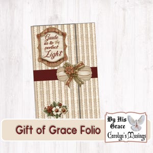 Puede incluir: Un folio decorativo con un fondo a rayas, una cinta burdeos y adornos florales. El texto "Guide us to Thy perfect Light" se muestra en la parte delantera. También son visibles las palabras "Gift of Grace Folio".